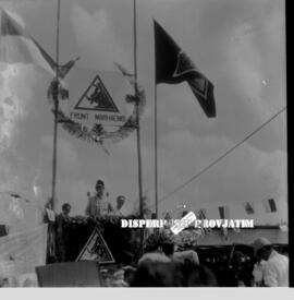 Seorang pejabat / tokoh sedang berpida di podium, tampak diatas podium logo PNI dengan bertuliska...