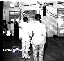 Seorang perwira sedang membuka penutup papan pada pembukaan eksposisi / pameran operation board m...