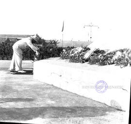 Seorang pejabat sedang meletakkan karangan bunga dalam upacara peringatan Hari Maritim di depan k...