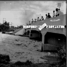 Warga Porong menyaksikan derasnya banjir dari atas jembatan kereta api pada banjir Porong, 12 – 2...