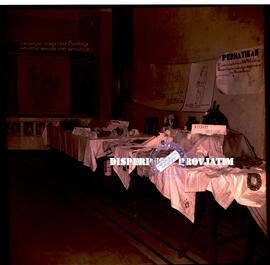 Meja stand berisi kain dan baju dalam acara Ceramah Pekan Kesejahteraan Keluarga (PWKJ), 24 – 10 ...