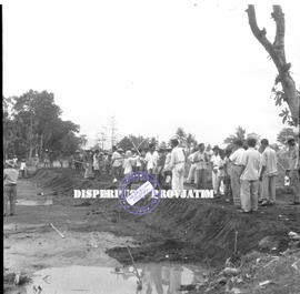 Masyarakat sedang bergotong  royong membuat tanggul setelah bencana alam banjir di Jember, 13 – 1...