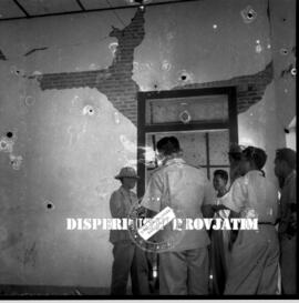 Kunjungan para pejabat dengan latar  belakang bangunan yang rusak parah, foto  diambil setelah ke...