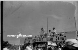 Sebuah panggung / podium dengan seorang pejabt sedang berpidato dengan spanduk bertuliskan KUATKA...