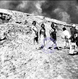 Tiga orang lelaki suku tengger tengah menawarkan souvenir kepada wisatawan di lereng kawah gunung...